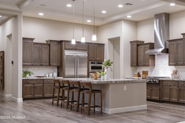 kitchen with a towering ceiling, appliances with stainless steel finishes, and a kitchen island with sink