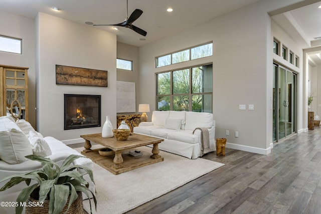 living room featuring a healthy amount of sunlight, wood-type flooring, and a high ceiling