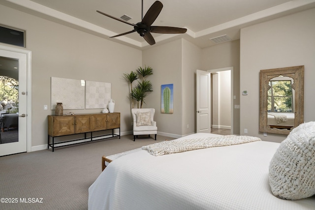 carpeted bedroom featuring a raised ceiling, access to exterior, and ceiling fan