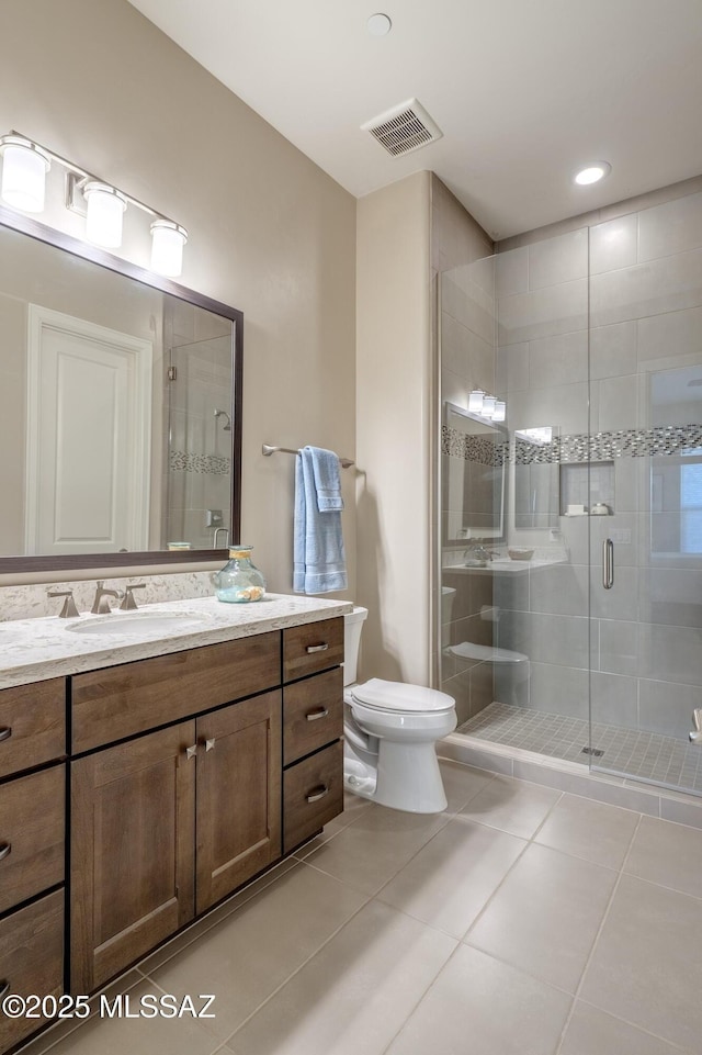 bathroom featuring tile patterned flooring, an enclosed shower, vanity, and toilet