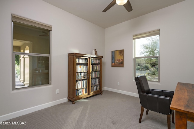 carpeted home office featuring ceiling fan