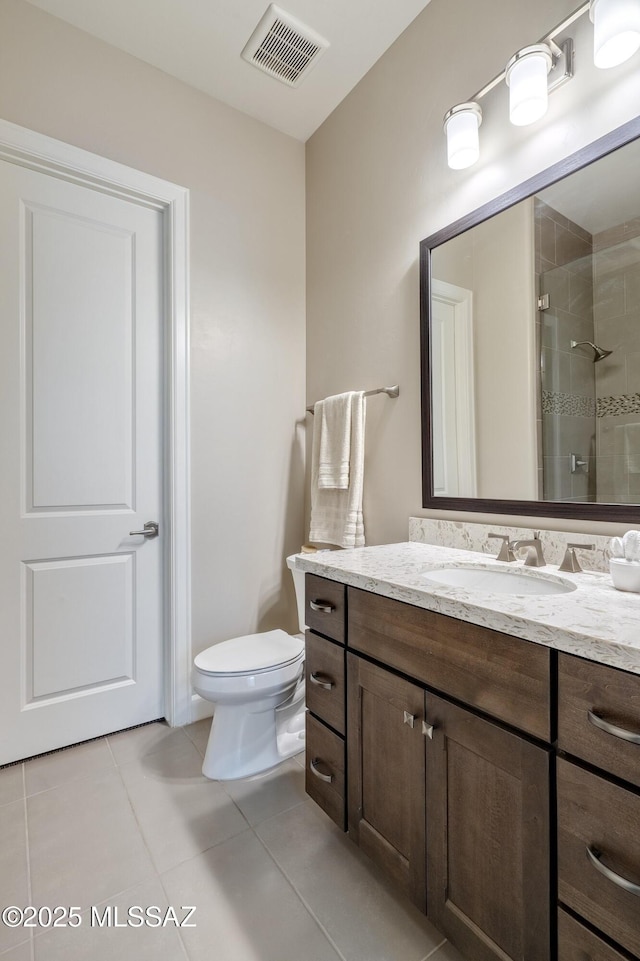 bathroom with vanity, toilet, tile patterned floors, and walk in shower