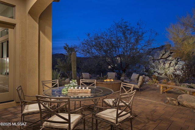 patio terrace at dusk featuring an outdoor fire pit