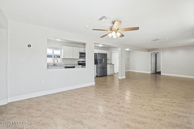 unfurnished living room with ceiling fan and sink