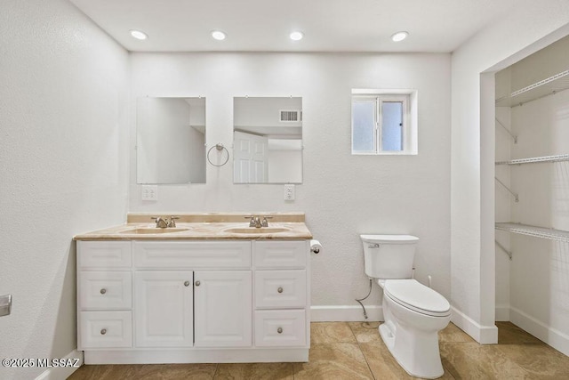 bathroom with toilet, tile patterned floors, and vanity