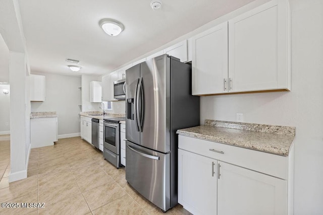 kitchen featuring appliances with stainless steel finishes, white cabinets, and sink