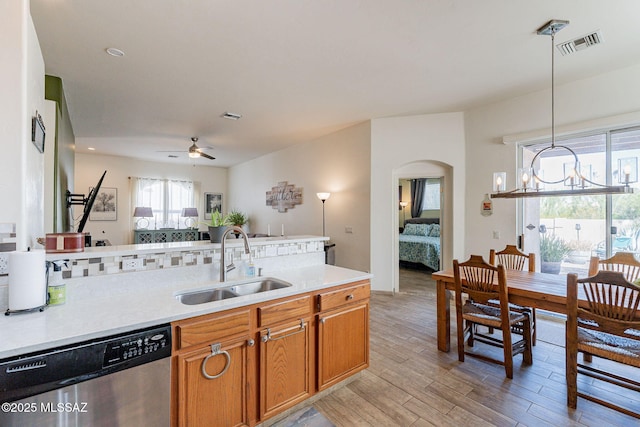 kitchen with pendant lighting, sink, ceiling fan, stainless steel dishwasher, and light wood-type flooring