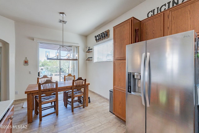 dining area with a notable chandelier and light hardwood / wood-style flooring