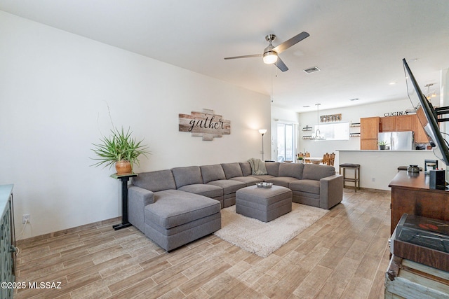 living room with ceiling fan and light hardwood / wood-style floors