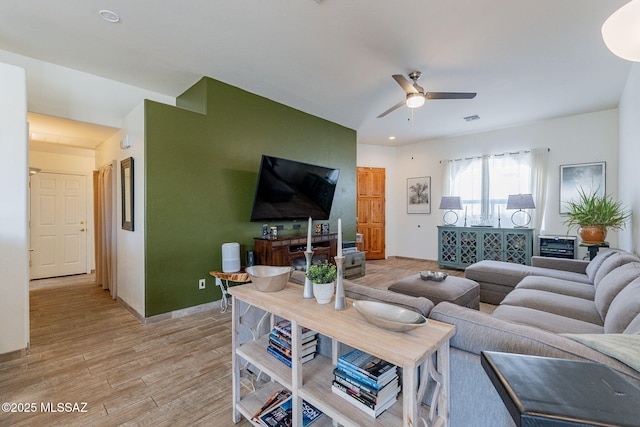 living room featuring light hardwood / wood-style floors and ceiling fan