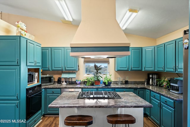 kitchen featuring stainless steel appliances, blue cabinetry, a kitchen bar, and custom range hood