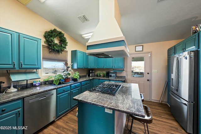 kitchen with blue cabinets, stainless steel appliances, island range hood, and a center island