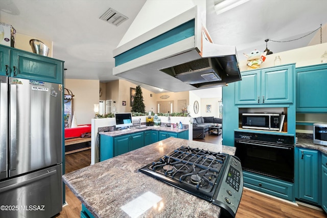 kitchen with range hood, a center island, stainless steel appliances, lofted ceiling, and stone countertops