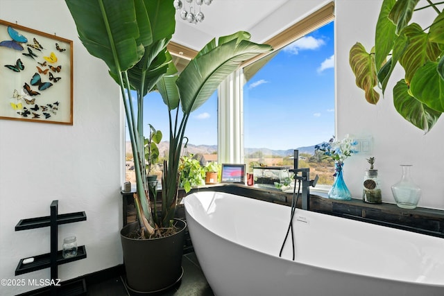 bathroom with a tub to relax in and a mountain view