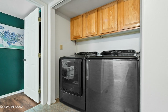 clothes washing area with cabinets, separate washer and dryer, and dark hardwood / wood-style floors