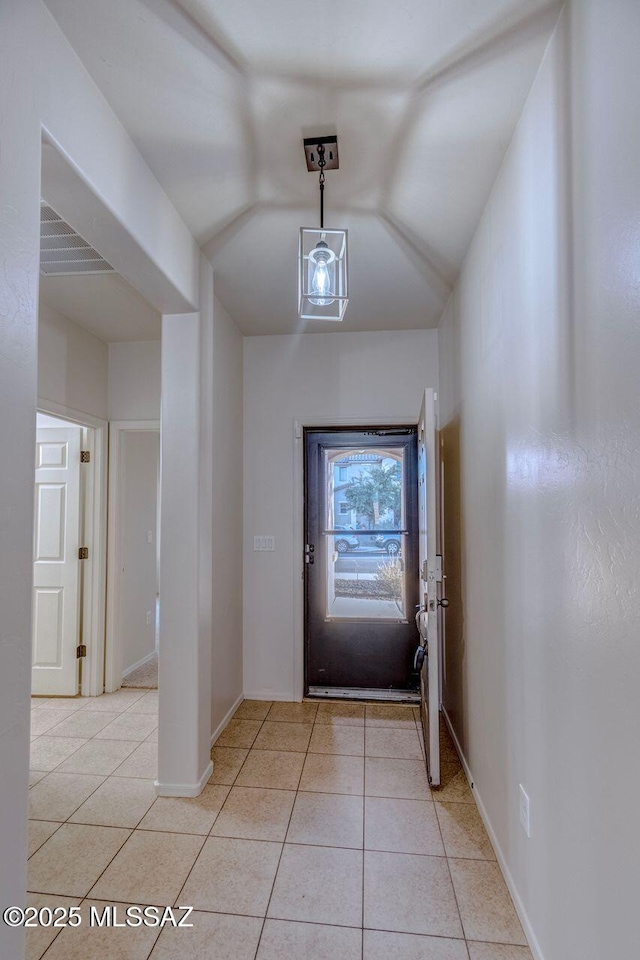 entrance foyer featuring visible vents, baseboards, vaulted ceiling, and light tile patterned flooring