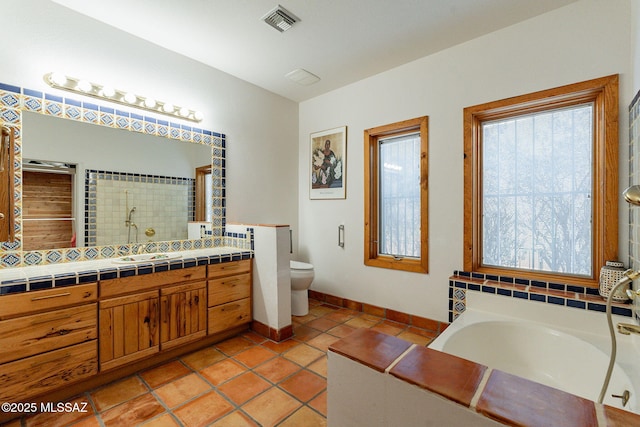 bathroom featuring toilet, vanity, tile patterned floors, and plenty of natural light