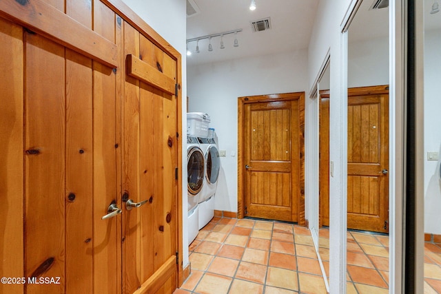 laundry room featuring separate washer and dryer, light tile patterned flooring, and rail lighting