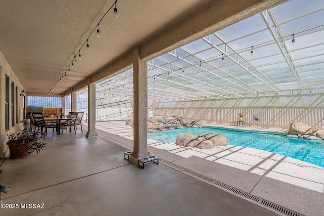 view of swimming pool with a lanai and a patio