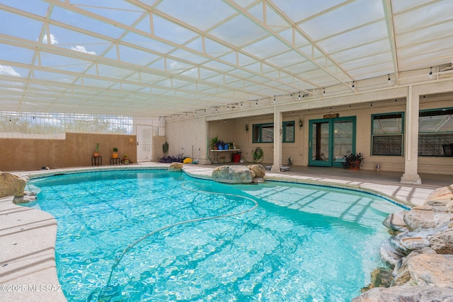 view of pool featuring glass enclosure