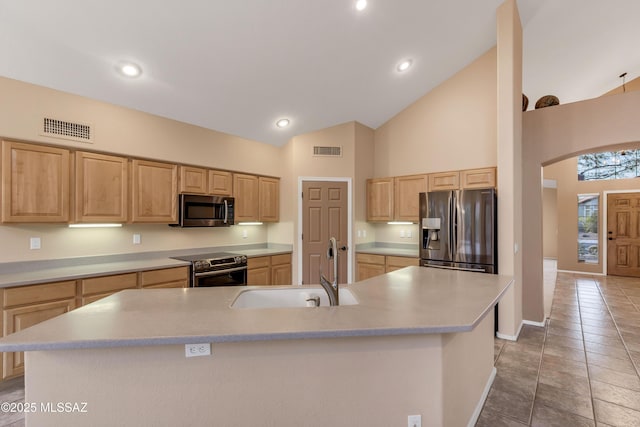 kitchen with appliances with stainless steel finishes, sink, a kitchen island with sink, and light brown cabinets