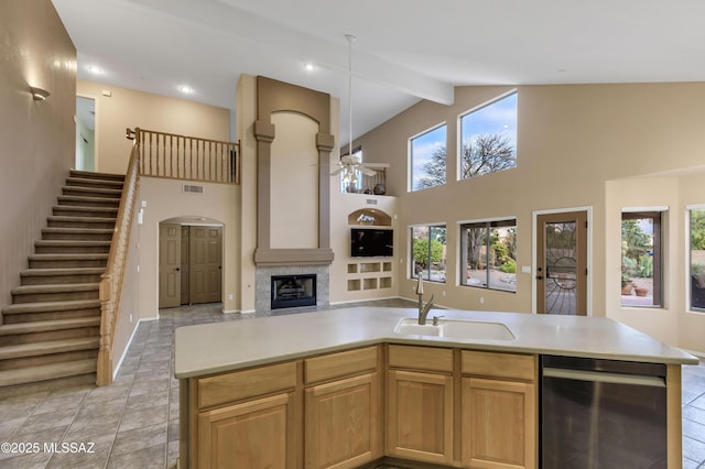 kitchen featuring beamed ceiling, ceiling fan, sink, and high vaulted ceiling