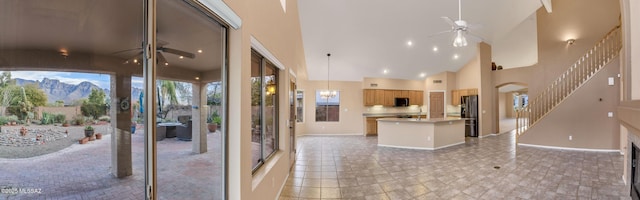 kitchen featuring high vaulted ceiling, a kitchen island, pendant lighting, ceiling fan, and black appliances