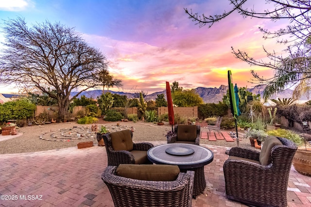 patio terrace at dusk featuring a mountain view