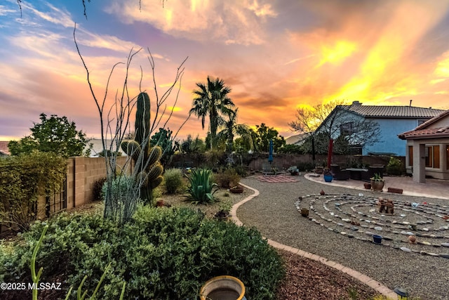 yard at dusk featuring a patio