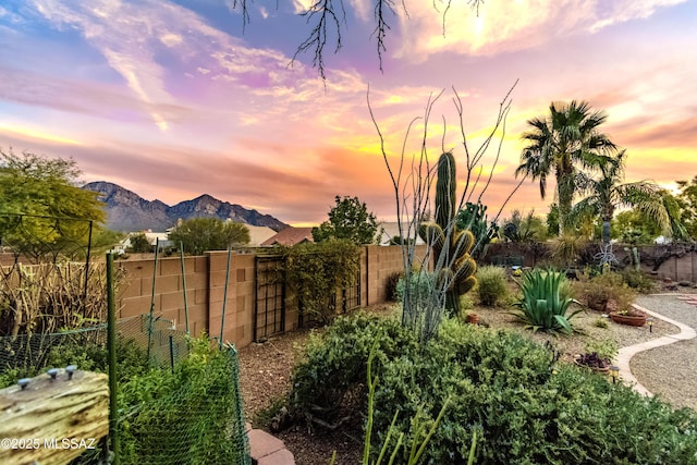 yard at dusk featuring a mountain view