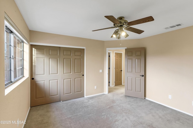 unfurnished bedroom with ceiling fan, light colored carpet, and a closet