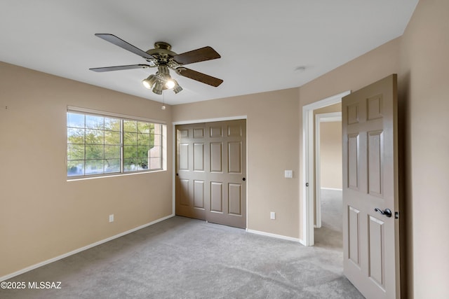 unfurnished bedroom with ceiling fan, light colored carpet, and a closet