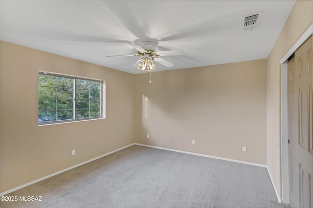 spare room with ceiling fan and light carpet