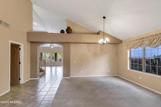 spare room with carpet, high vaulted ceiling, and a chandelier