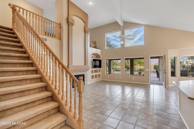 tiled living room with a tiled fireplace, ceiling fan, high vaulted ceiling, and beamed ceiling