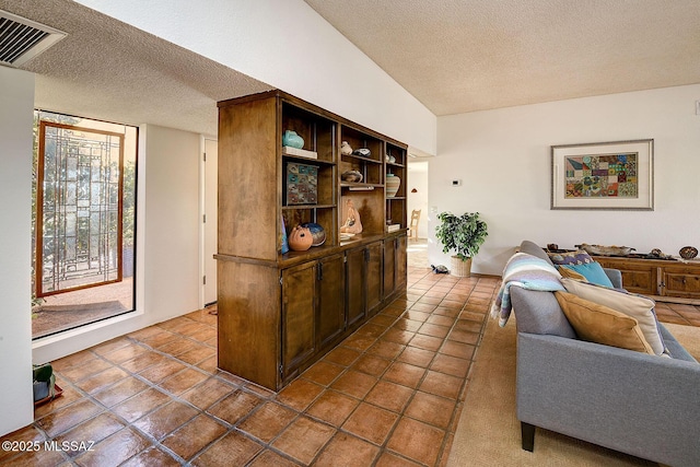 living room with tile patterned floors, vaulted ceiling, and a textured ceiling