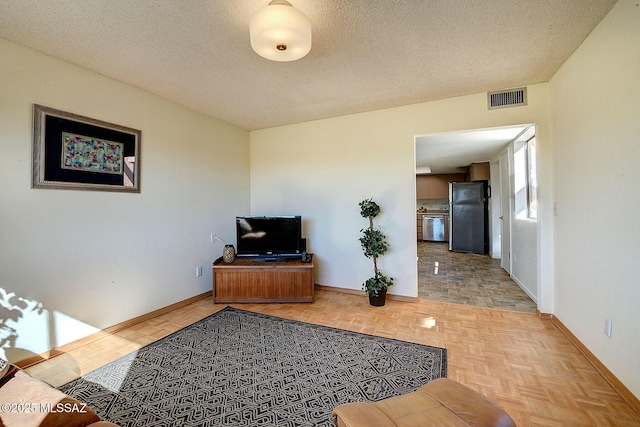 living room featuring light parquet floors and a textured ceiling