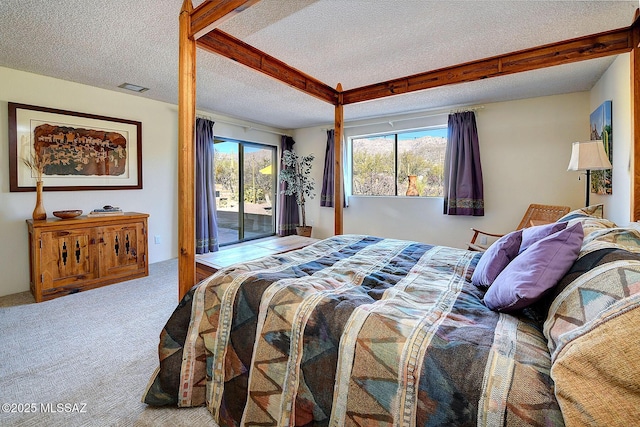 carpeted bedroom with access to exterior and a textured ceiling