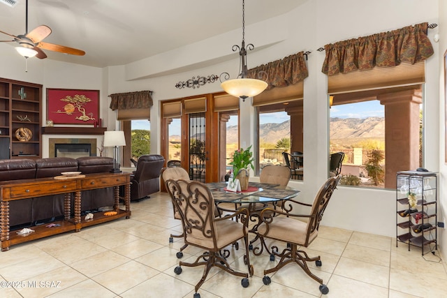 dining space featuring a mountain view, vaulted ceiling, ceiling fan, and light tile patterned flooring