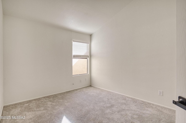 spare room featuring light colored carpet