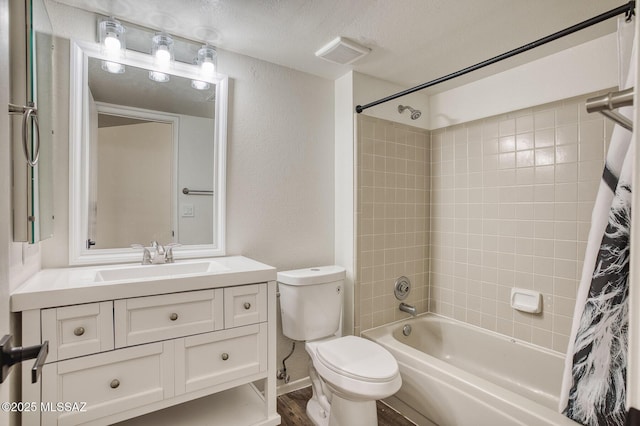 full bathroom featuring a textured ceiling, hardwood / wood-style floors, toilet, shower / bath combo with shower curtain, and vanity