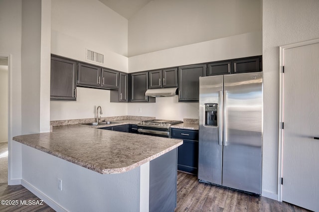 kitchen with appliances with stainless steel finishes, sink, high vaulted ceiling, and kitchen peninsula