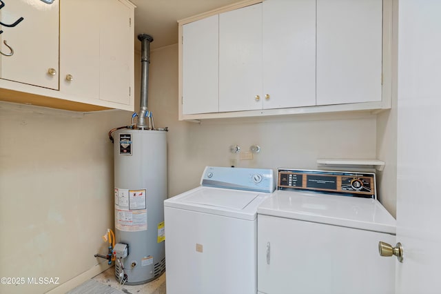 laundry area with washing machine and dryer, gas water heater, and cabinets