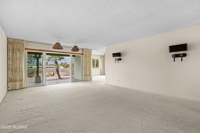 empty room with carpet floors and a textured ceiling