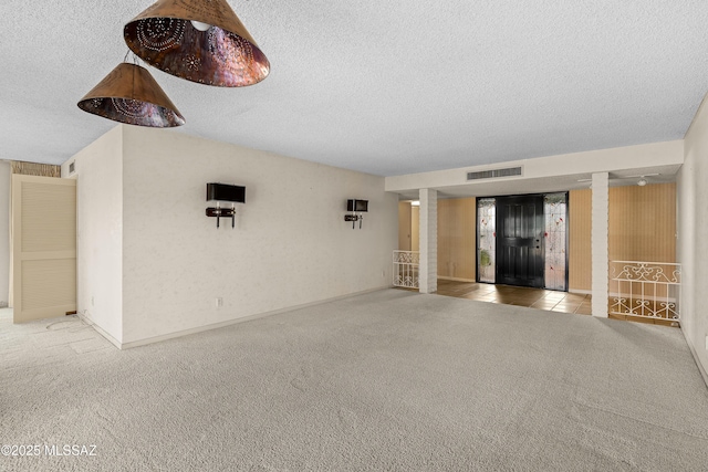 unfurnished living room with a textured ceiling and light colored carpet