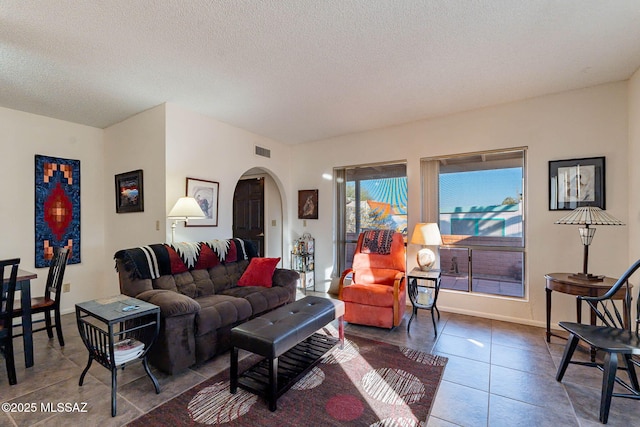 tiled living room featuring a textured ceiling