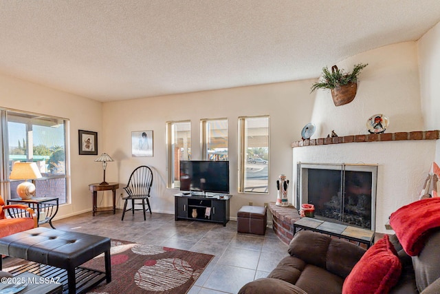 living room featuring a fireplace, a wealth of natural light, and a textured ceiling