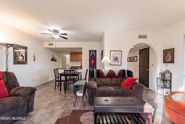 living room featuring a textured ceiling and ceiling fan