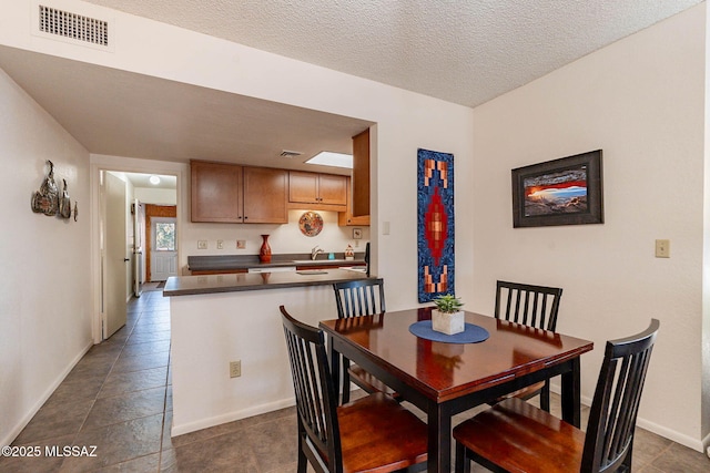 dining room with a textured ceiling and sink