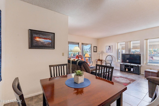 dining room featuring a textured ceiling, a wealth of natural light, and tile patterned flooring